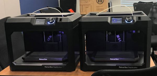 two 3D printers on a table