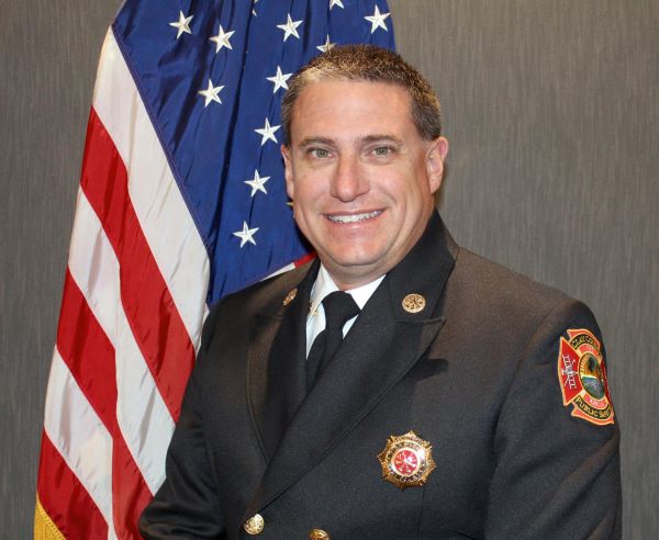 Headshot of Chief Boree posed in front of a flag