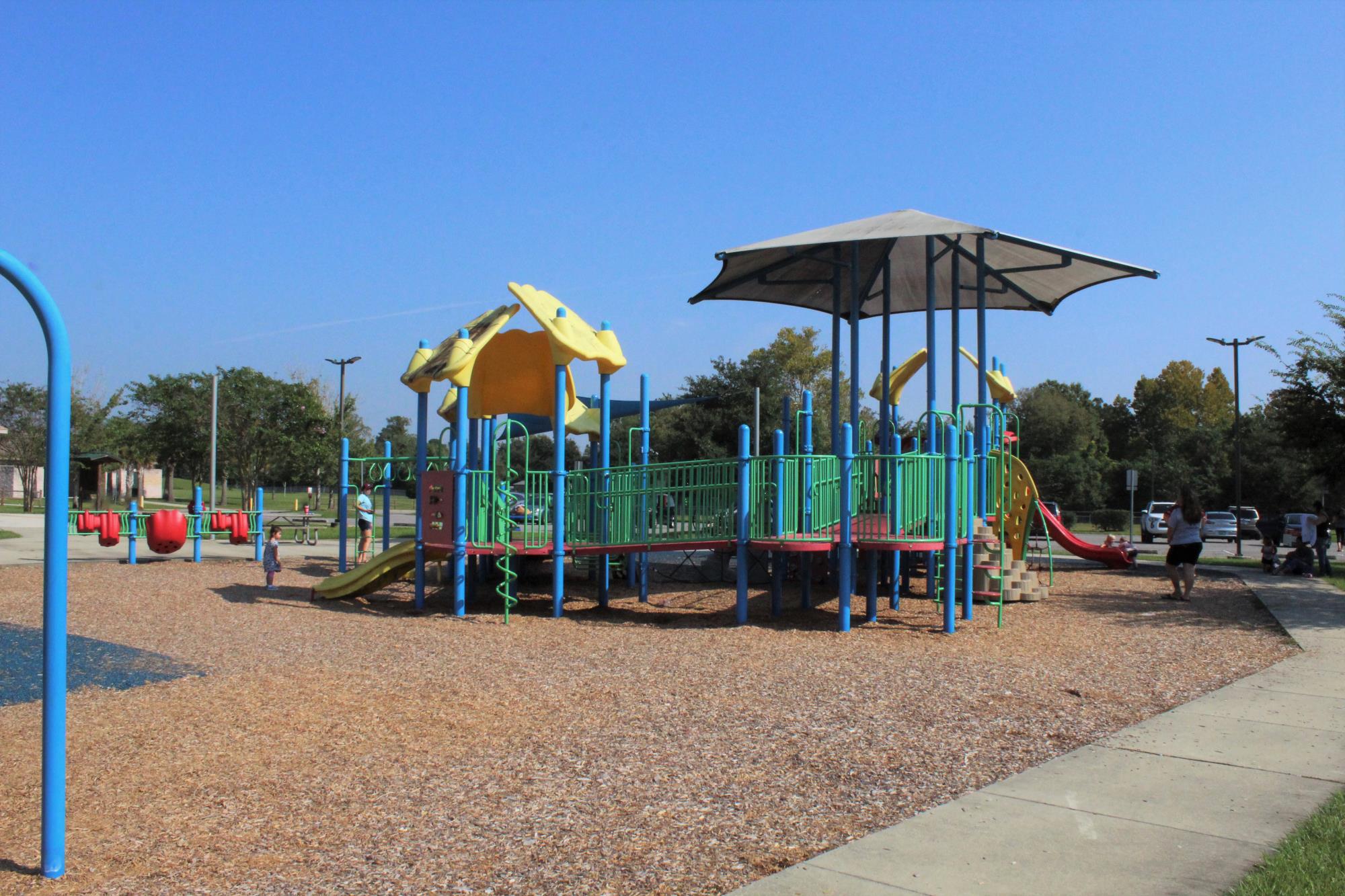 Playground equipment surrounded by a sidewalk and mulch