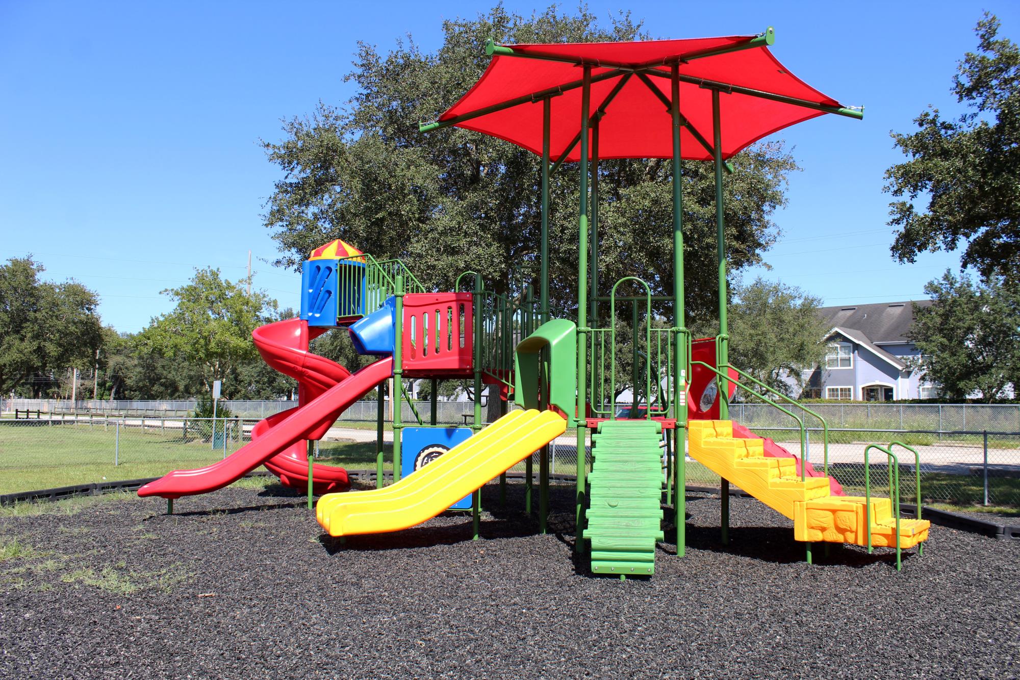 Playground with a red and yellow slide with steps and climbing options