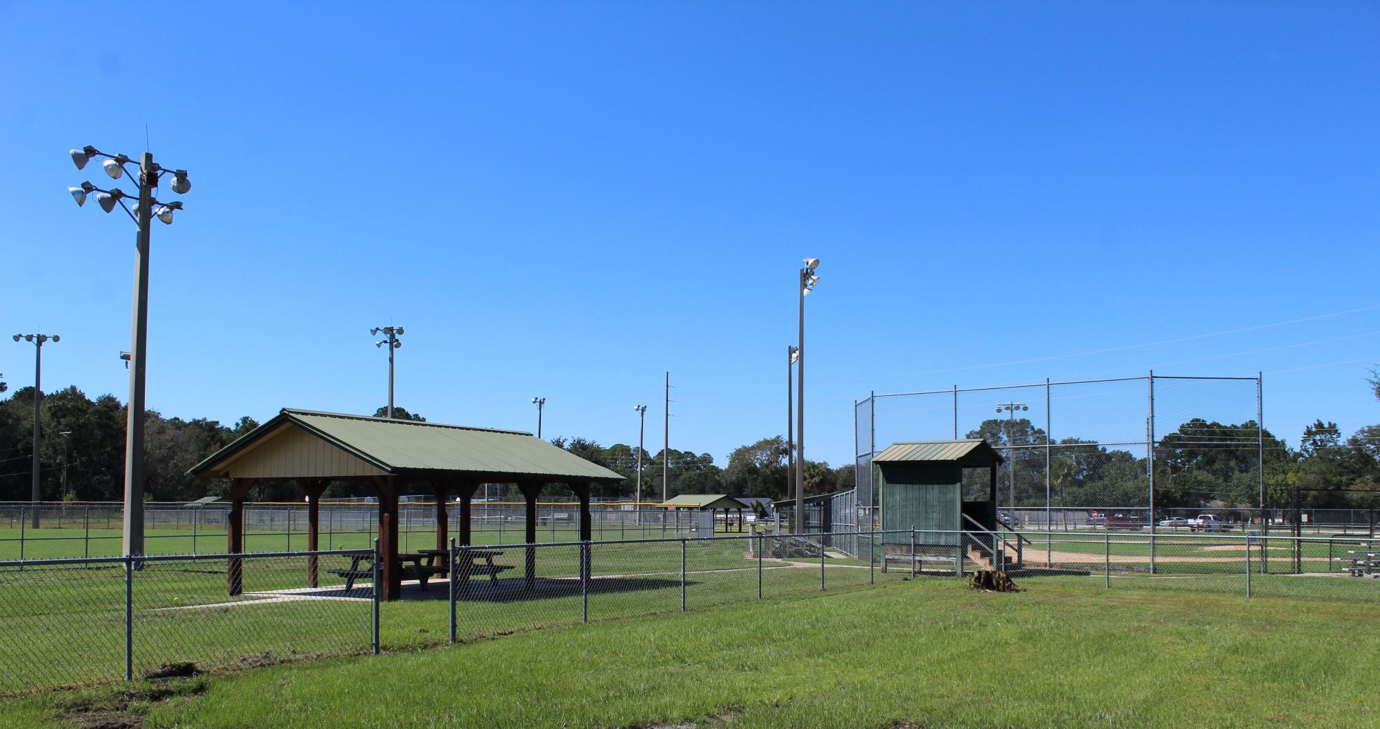 View of a pavilion with picnic tables and multiple ball fields