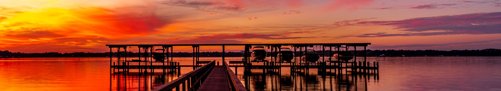 Pier with boat house and sunrise